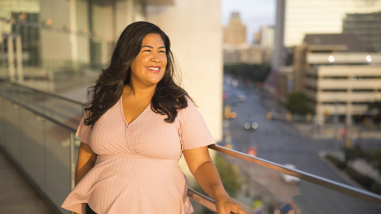 Flor De Maria McNally smiling on a city balcony