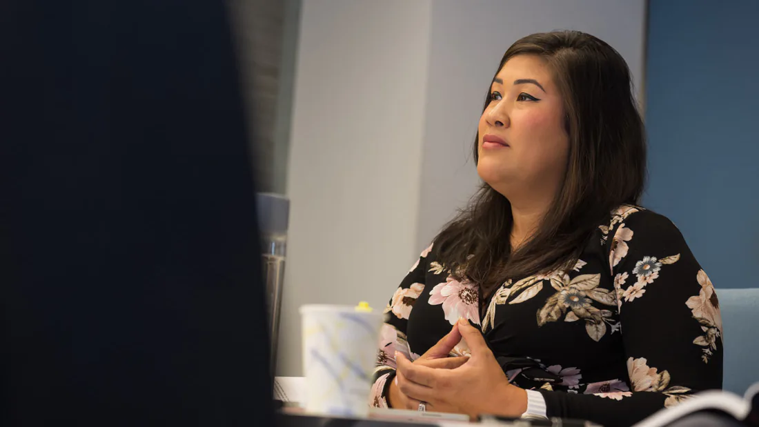 Flor De Maria McNally listening thoughtfully at a team meeting