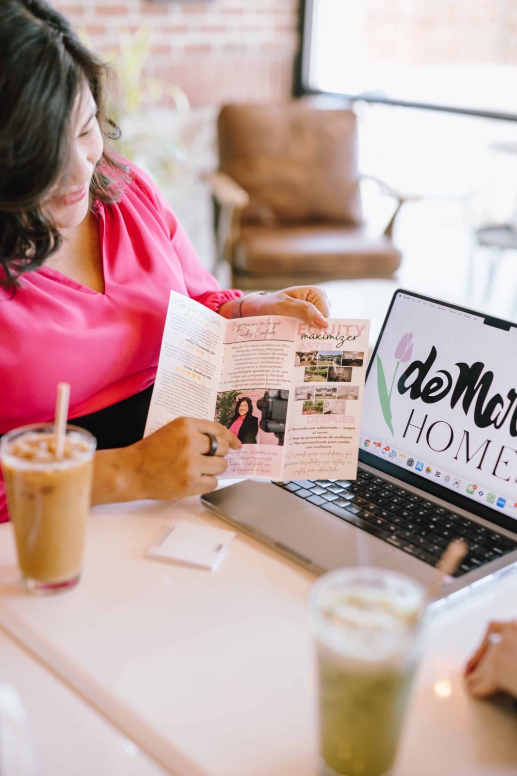 Flor reviewing printed materials beside a laptop