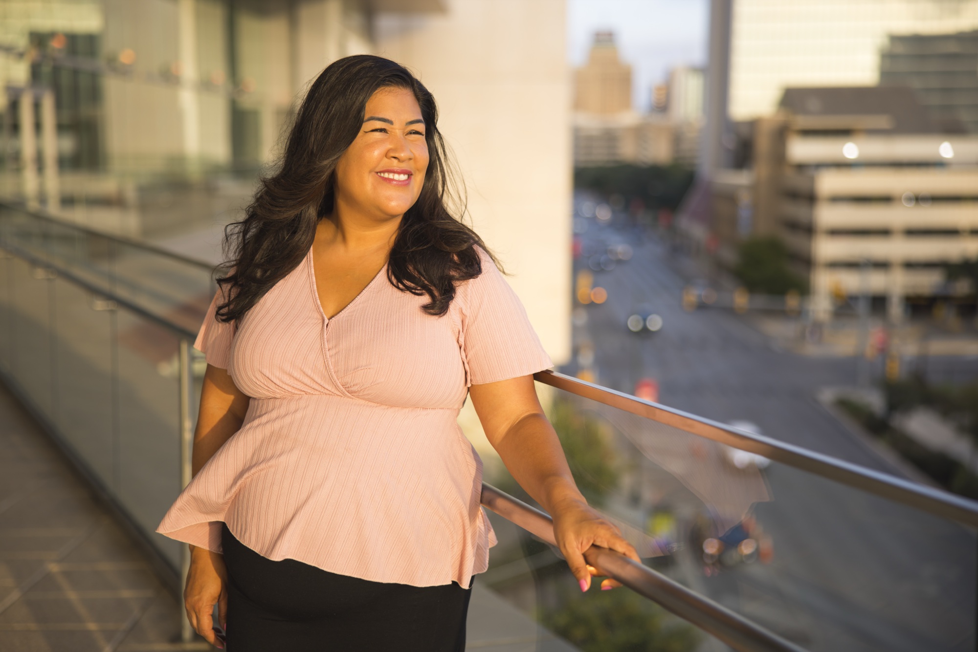 Flor De Maria McNally smiling on a city balcony