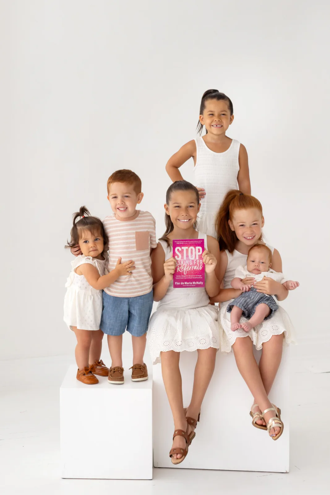 Flor's six children holding a copy of her book